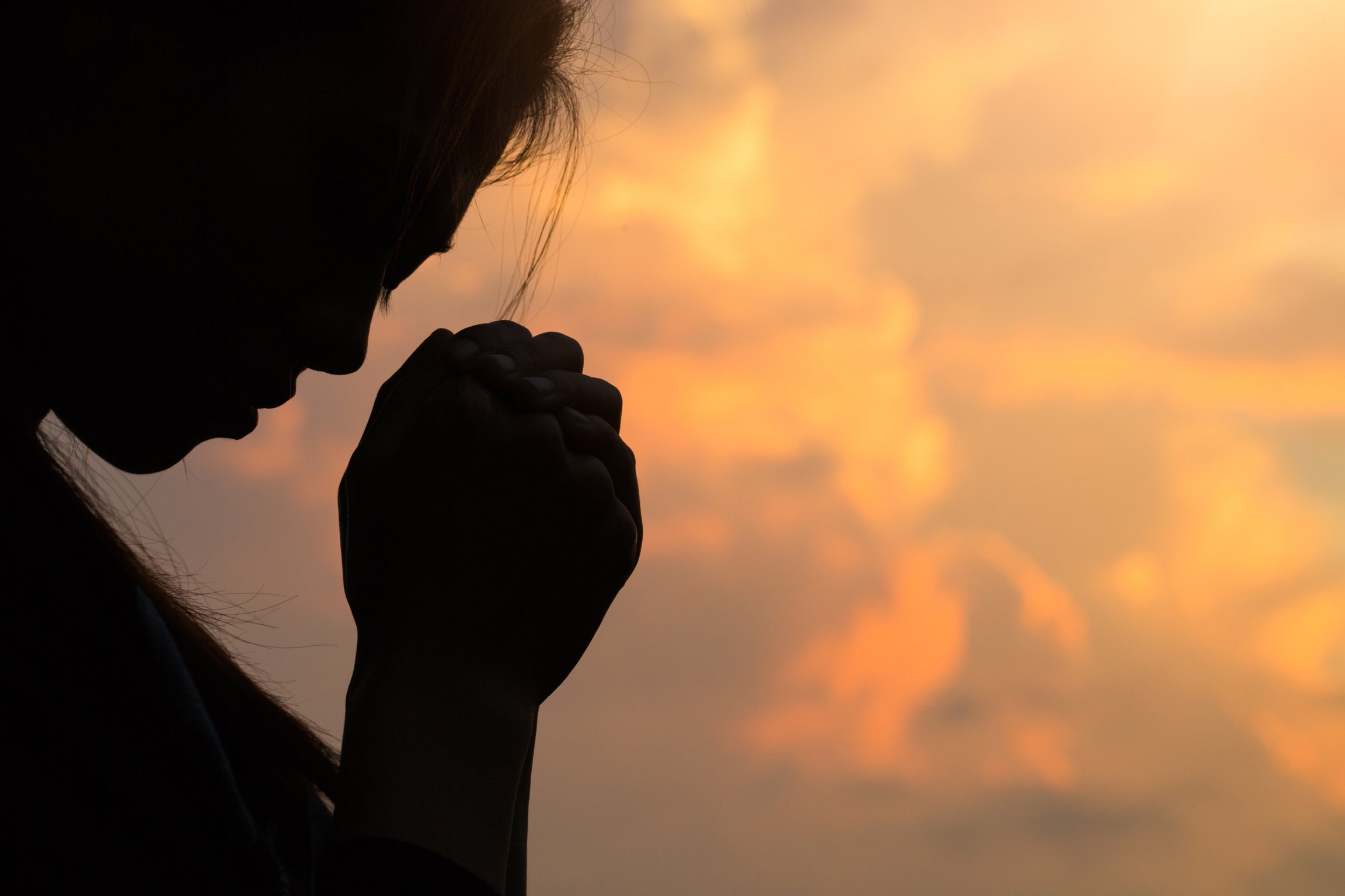 Silhouette of woman hands praying to god with the bible. Woman Pray for god blessing to wishing have a better life. Christian life crisis prayer to god.